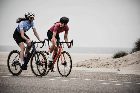 two women cyclists at a beach